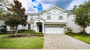 A two-story house with a garage, a driveway, and a well-maintained lawn. - 8BR Golf Resort Villa/Private Pool+Theater at home (Four Corners)
