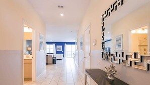 A hallway with a kitchen area, a black countertop, and a decorative wall piece. - 8BR Golf Resort Villa/Private Pool+Theater at home (Four Corners)
