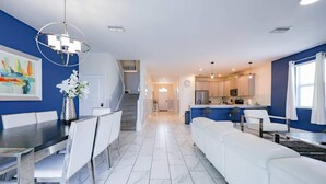 A modern kitchen with white cabinets, a dining area with a white table and chairs, and a living area with a white sofa. - 8BR Golf Resort Villa/Private Pool+Theater at home (Four Corners)