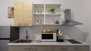A compact kitchen with a microwave, sink, and cabinets.