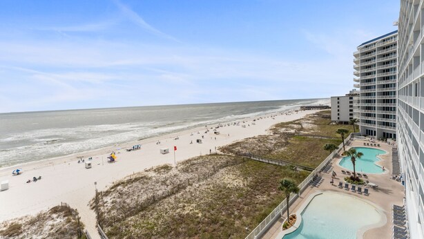 A beach view with a hotel, sandy beach, and a swimming pool. - Lighthouse 603, Owner Managed. Beautiful Beachfront Condo (Gulf Shores)
