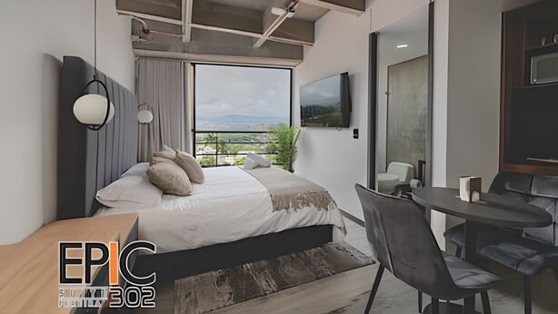 Une chambre moderne avec un grand lit, un bureau et une chaise. Une fenêtre offre une vue sur l’extérieur.