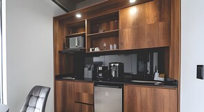 A modern kitchen with wooden cabinets, a stainless steel refrigerator, and a black countertop. - Epic Suite 302 Deluxe Aeropuerto (Pereira)