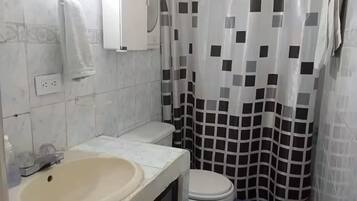 A bathroom with a sink, toilet, and shower curtain.