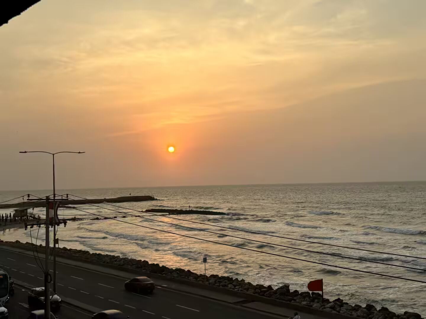 A coastal road with a sunset in the background.