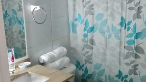 A bathroom with a toilet, sink, and mirror. - Alojamientos On Santiago (Santiago)