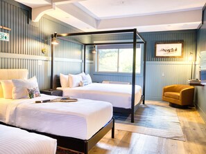 A bedroom with two beds, a canopy bed, a chair, a TV, and a window. - Hideaway Inn Mt.Sunapee (Newbury)