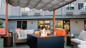 An outdoor patio with a fire pit, seating, and a covered area. - Hideaway Inn Mt.Sunapee (Newbury)