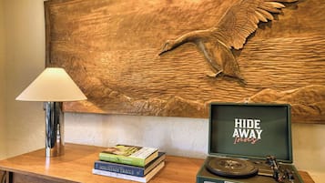Ein Holztisch mit einer Lampe, Büchern und einem alten Schallplattenspieler.