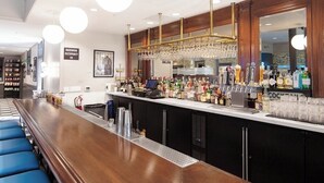 A bar area with a long counter, blue bar stools, and a variety of bottles and glasses. - Elegant Suite Near Charles M. Schulz Museum – Perfect for Couples + Wine Lovers (Santa Rosa)
