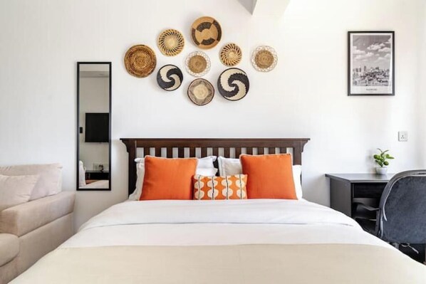 Habitación de hotel ordenada con cama, escritorio y silla.