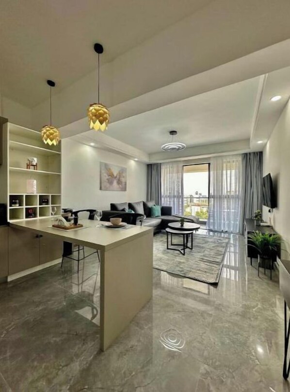 Una sala de estar moderna con un sofá, una mesa de centro y un comedor con una encimera de cocina.