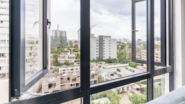A high-rise apartment with large windows offering a cityscape view.
