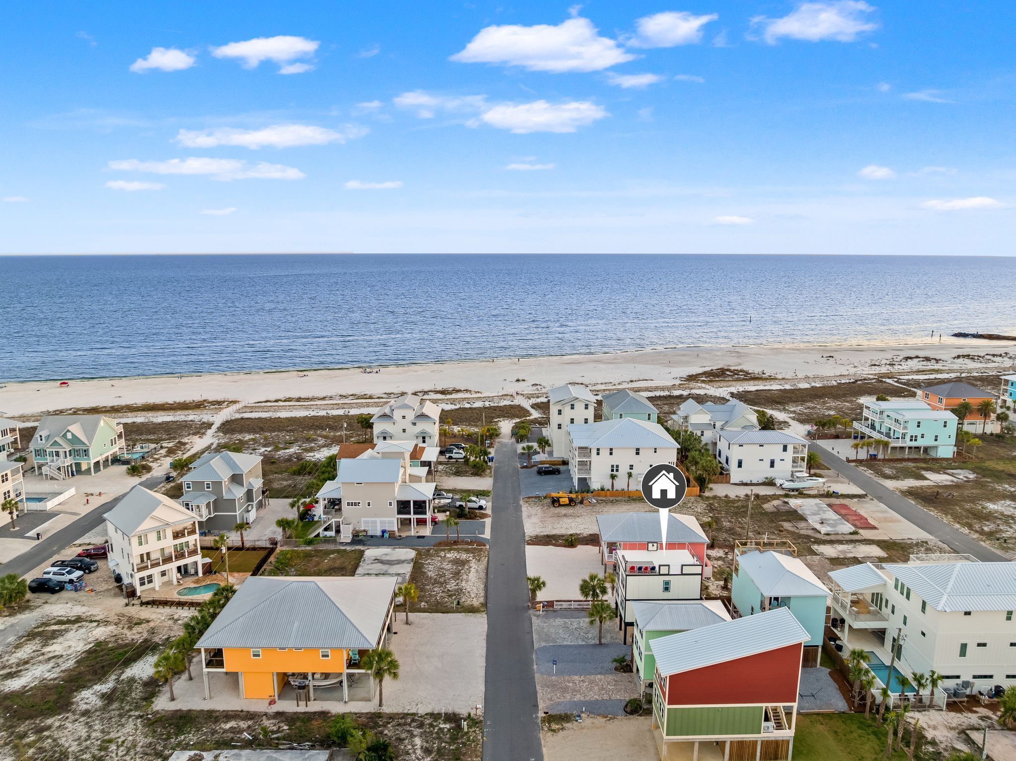 A coastal residential area with houses, a beach, and the ocean.
