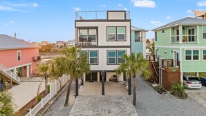 A modern multi-story building with a flat roof, large windows, and a balcony.