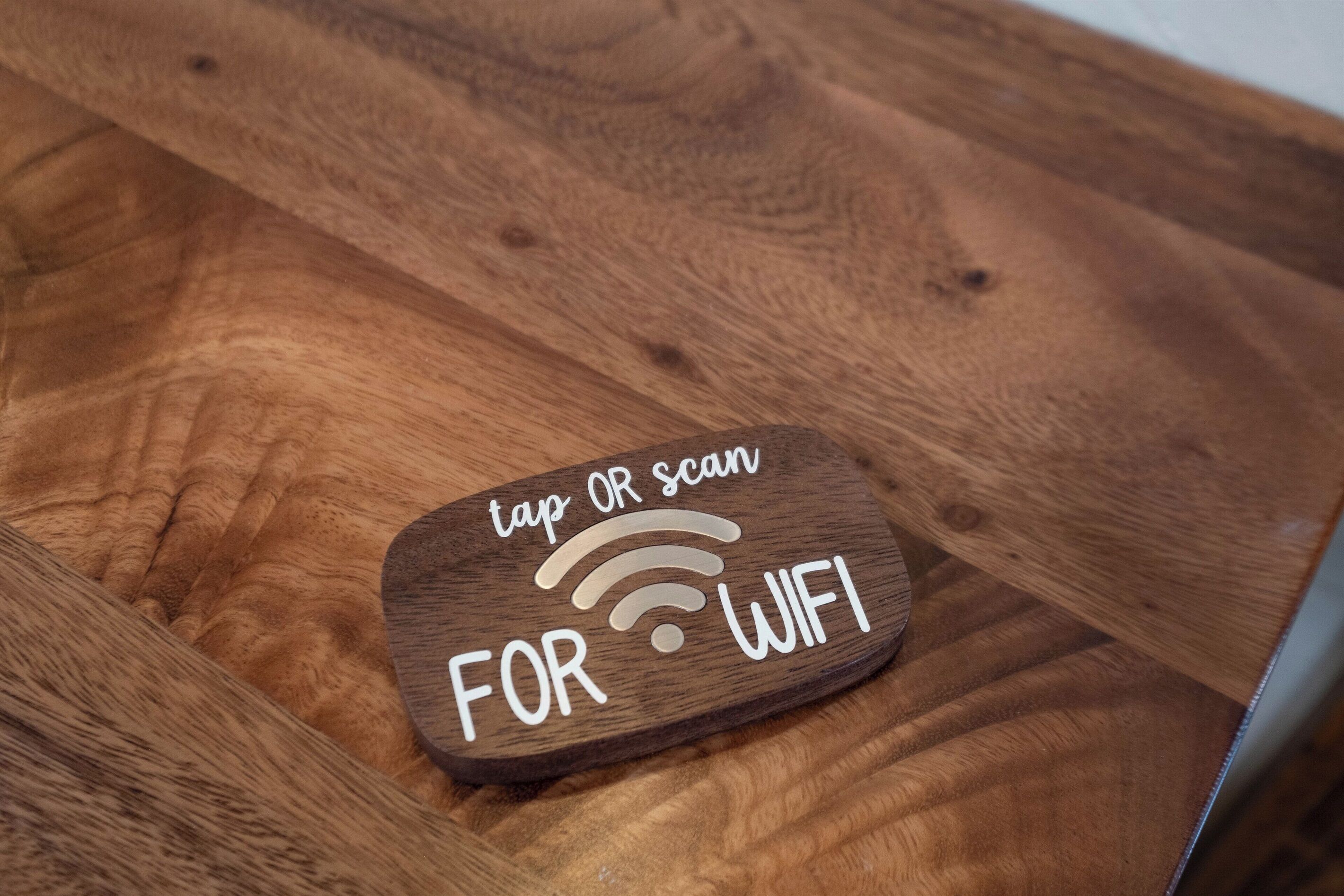 A wooden sign with a WiFi symbol and the text 'tap OR scan FOR WIFI'.