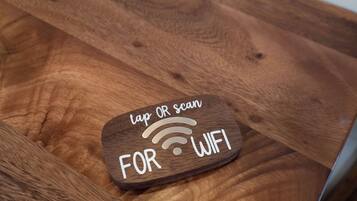 A wooden sign with a WiFi symbol and the text 'tap OR scan FOR WIFI'.