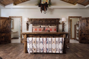 A rustic bedroom with a wooden headboard, two bedside lamps, and a patterned throw blanket. - Luxury Farm Living! With Magical wide open spaces (Nazareth)