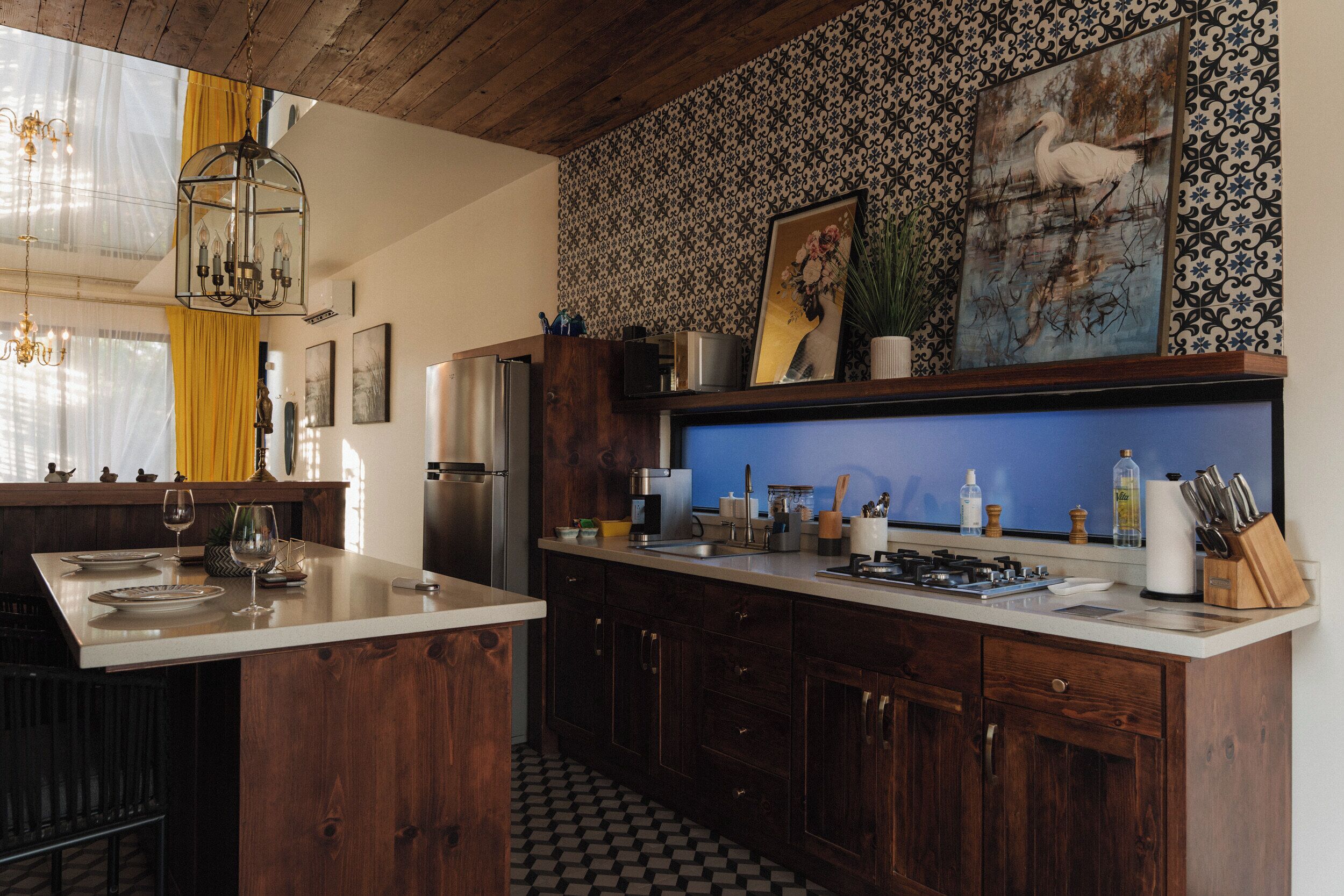 A kitchen with wooden cabinets, a central island, and a patterned backsplash.