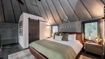 Un dormitorio con una cama grande, un cabecero de madera, una mesita de noche con lámpara y una ventana con persianas.