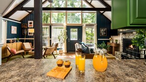 Eine Küche mit einer Granitabdeckung, einem Couchtisch und einem Essbereich mit einer Bank. Auf der Arbeitsfläche befinden sich zwei Gläser Orangensaft und eine Flasche Orangensaft.