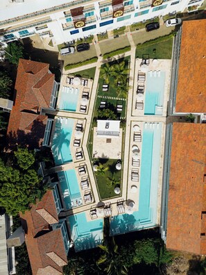 Ilmakuva hotellista, jossa on uima-allas, useita oleskelualueita ja parkkipaikka.