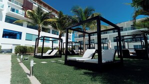 A modern hotel with a rooftop pool area featuring sun loungers and palm trees. - Lifestyle Holidays Vacation Club - Presidential Suites - 1 Bedroom suite (Cabarete)