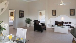 A spacious living area with a modern sofa, a glass coffee table, and a potted plant.