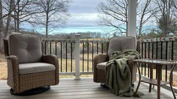 A covered outdoor seating area with wicker chairs and a small table.