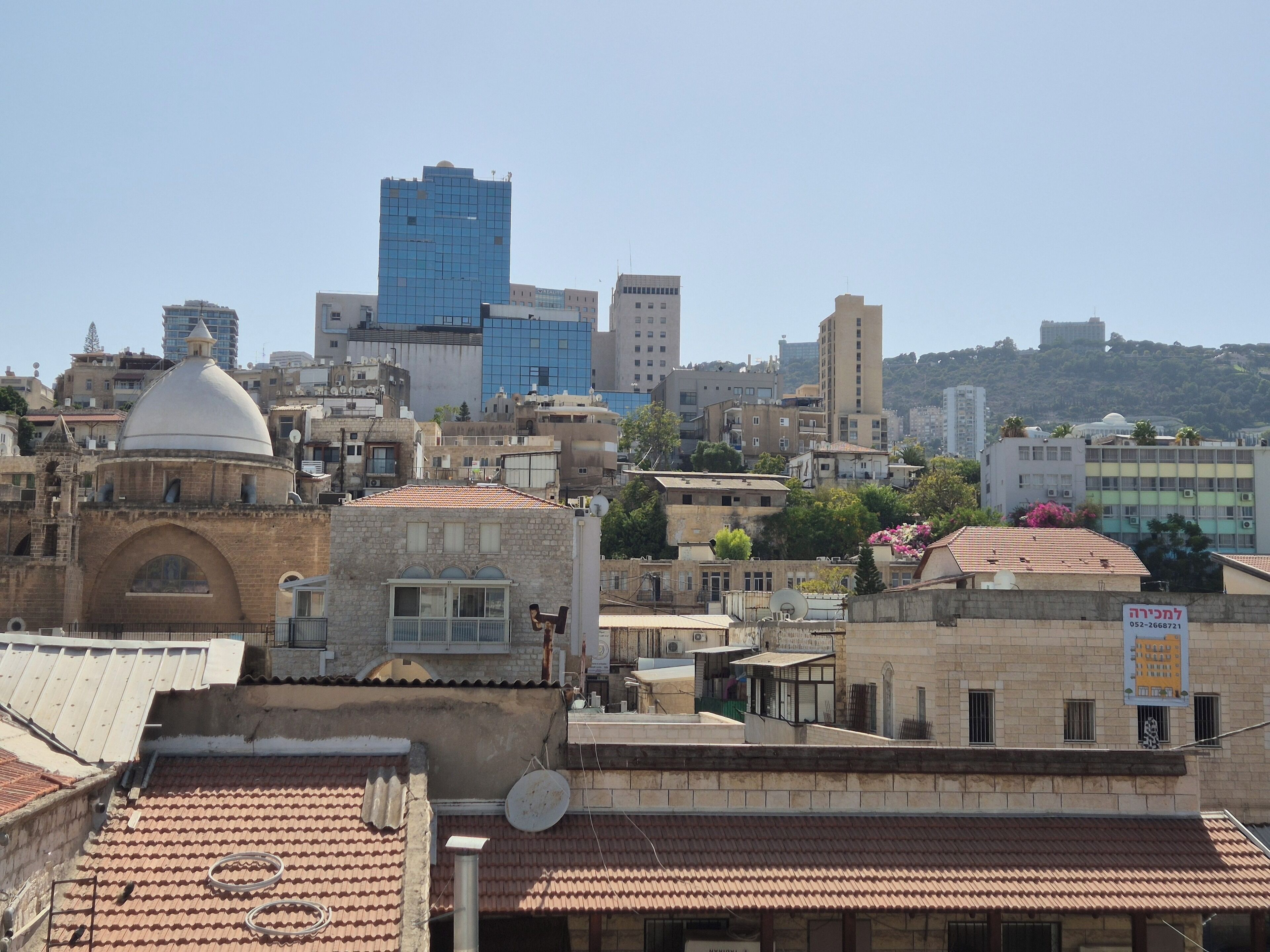 A cityscape with a mix of modern and traditional architecture, including a prominent dome and a tall blue building.