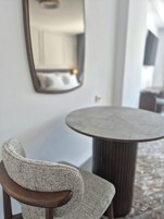 A round table with a textured chair in front.