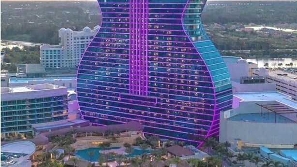 Un hôtel dont le bâtiment a la forme d’une guitare, qui dispose de plusieurs piscines et offre une vue sur le paysage environnant.