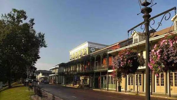 A street with buildings, a lamp post, and hanging flowers. - Hidden Gem Quiet 2BR Guest House Near Downtown with King Beds, Kitchen & Patio (Natchitoches)