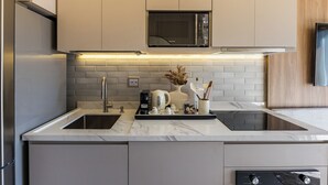 A modern kitchen with a stainless steel refrigerator, double sink, and a built-in microwave.