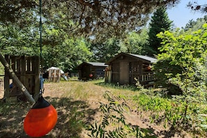 A rustic outdoor area with wooden structures, a swing set, and a red balloon. - Classic summer house with Arresø view (Frederiksværk)