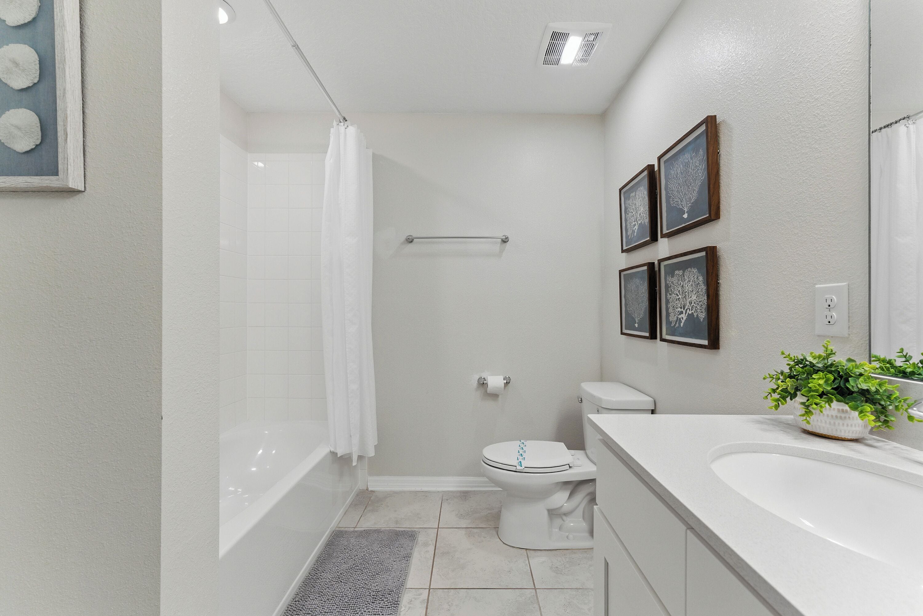 Une salle de bain équipée d’une baignoire, de toilettes, d’un lavabo et d’un rideau de douche.