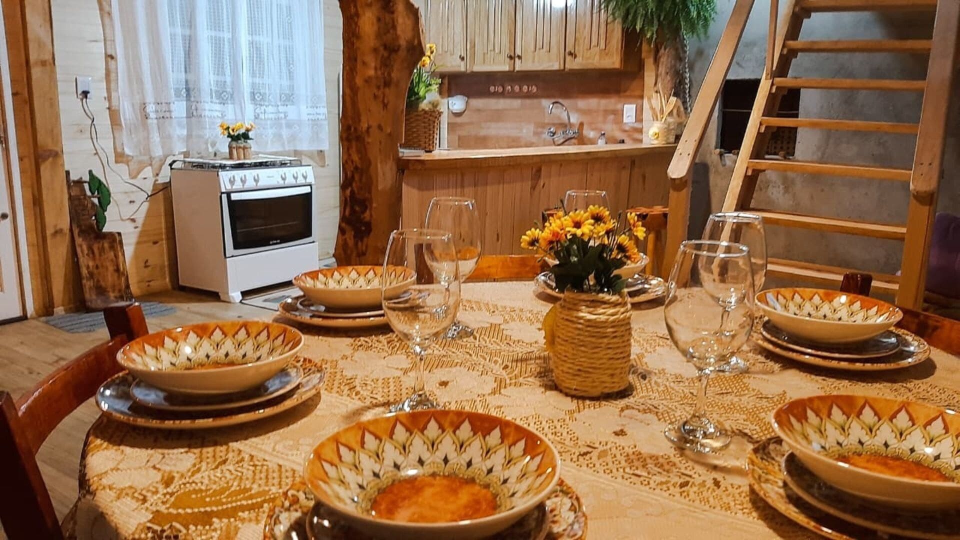 A dining table set with decorative bowls, wine glasses, and a centerpiece.