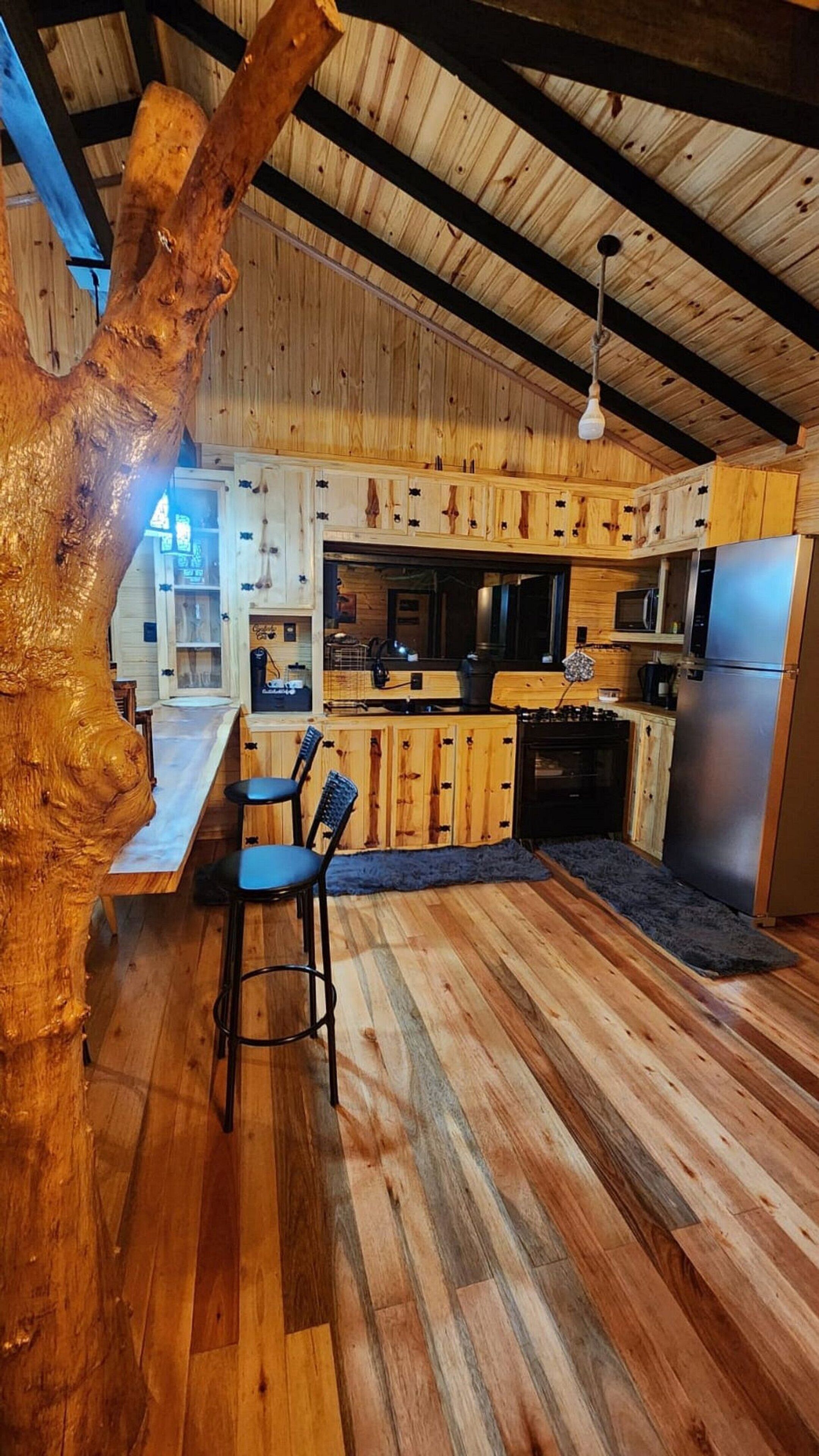 A rustic kitchen with wooden cabinets, a central island, and a built-in stove.