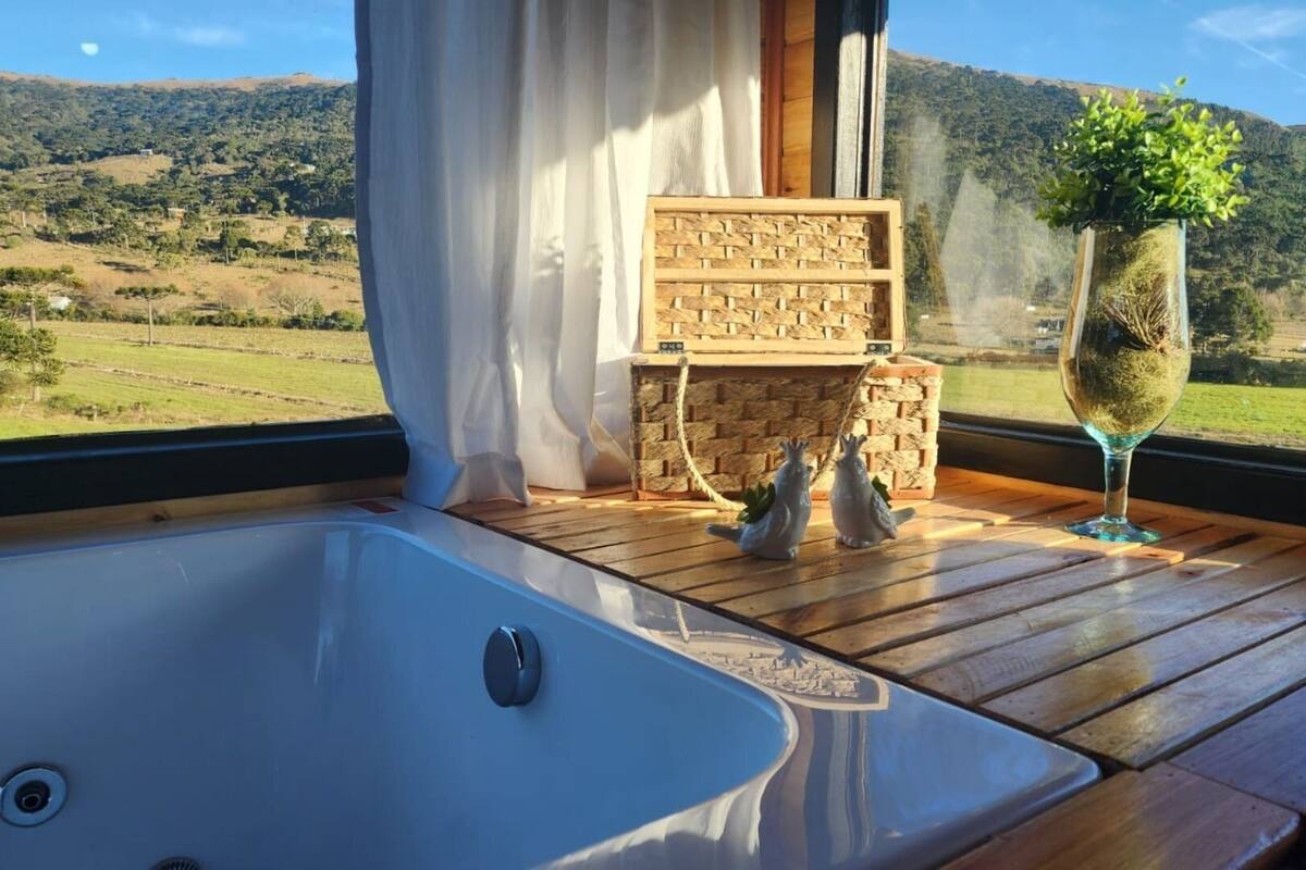 A wooden deck with a hot tub, a wicker basket, and a glass vase with a plant.