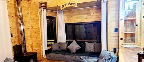 Um interior acolhedor em madeira, com sofás, espaço de bar e lareira.
