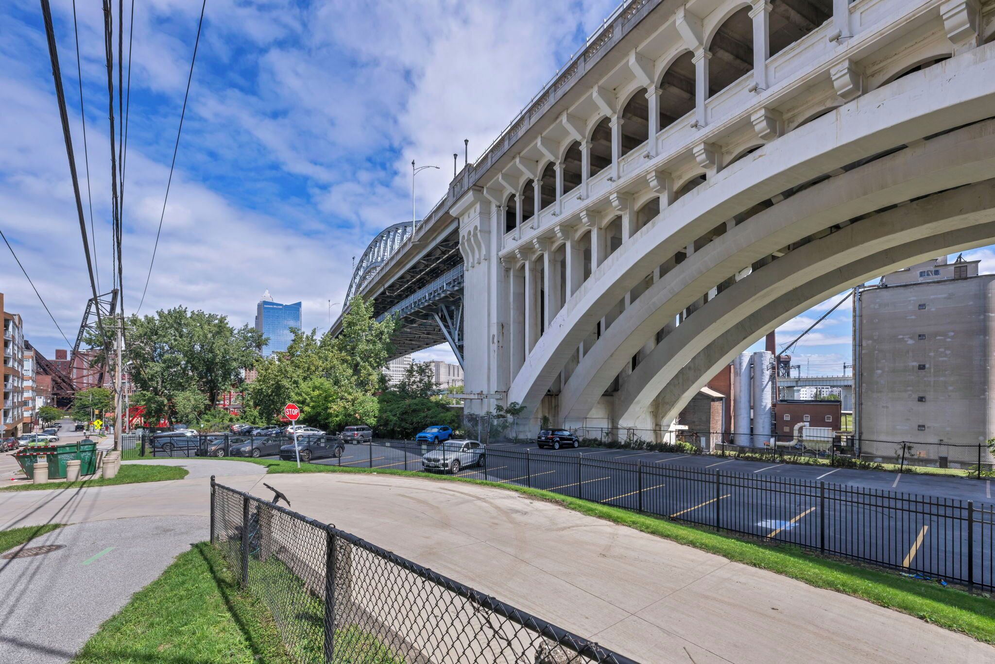 Une passerelle piétonne sous un pont, avec un ciel dégagé.