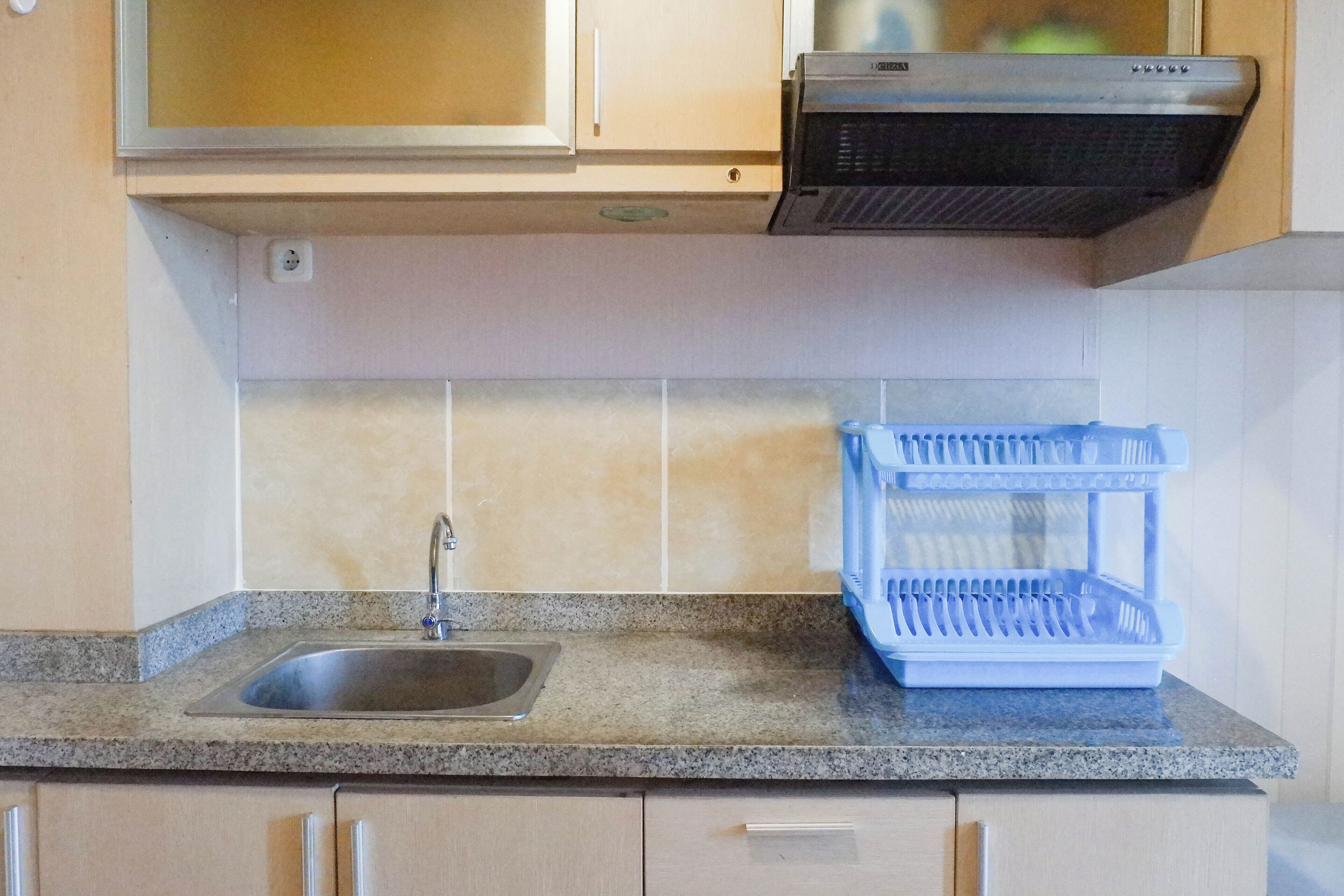 A kitchen with a granite countertop, a stainless steel sink, and a double oven.