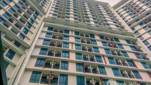 A multi-story hotel with a modern design, featuring balconies on each floor and a consistent architectural style. - Neat Studio At Lrt City Bekasi Apartment (Bekasi)