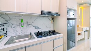 A modern kitchen with a marble backsplash, stainless steel sink, and a built-in oven. - Cozy Stay Studio At Lrt City Bekasi Apartment (Bekasi)