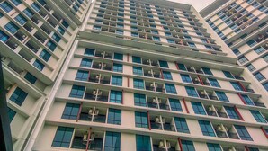 A multi-story building with a modern architectural design, featuring balconies on each floor. - Cozy Stay Studio At Lrt City Bekasi Apartment (Bekasi)