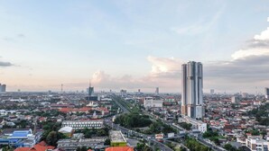 A cityscape with high-rise buildings, a wide road, and dense urban development. - Scenic Modern Studio Room At Tamansari Papilio Apartment (Surabaya)