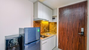Eine kleine Küche mit einem Kühlschrank, einem Wasserspender und einem Waschbecken.