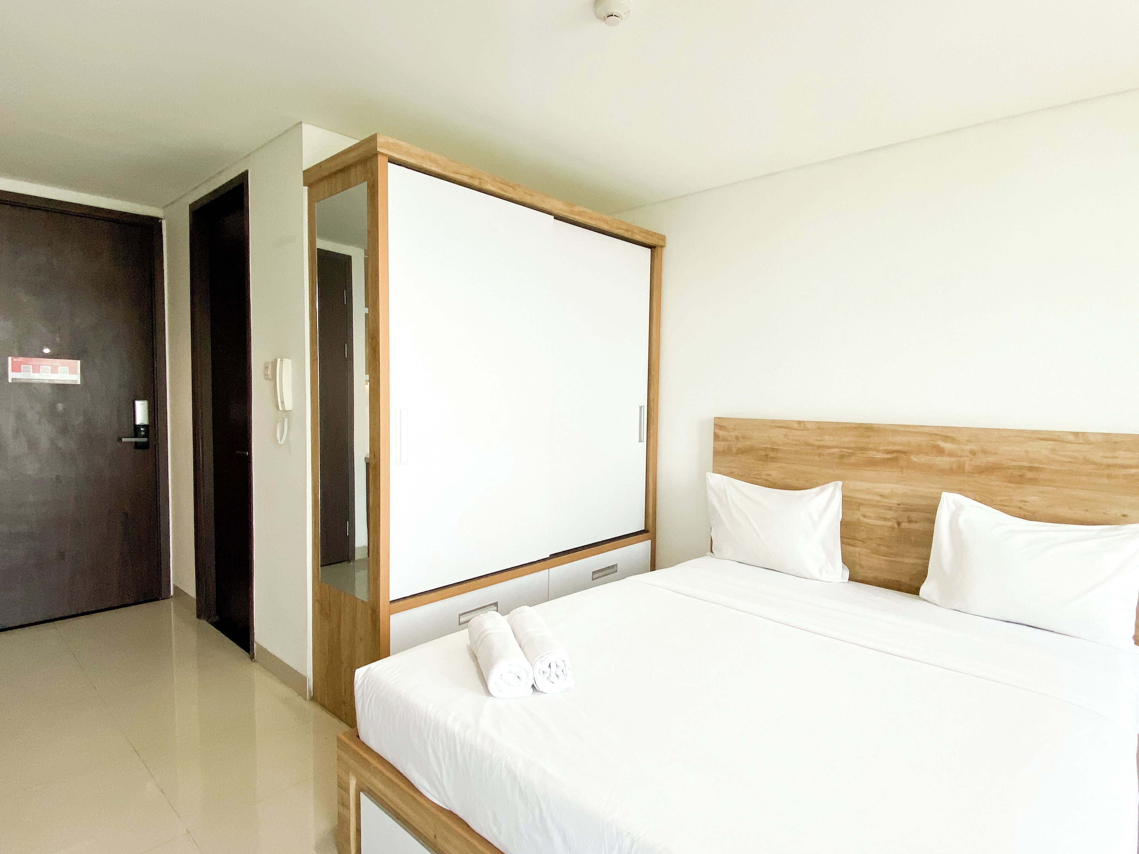 Ein Hotelzimmer mit Bett, Kleiderschrank und Tür.