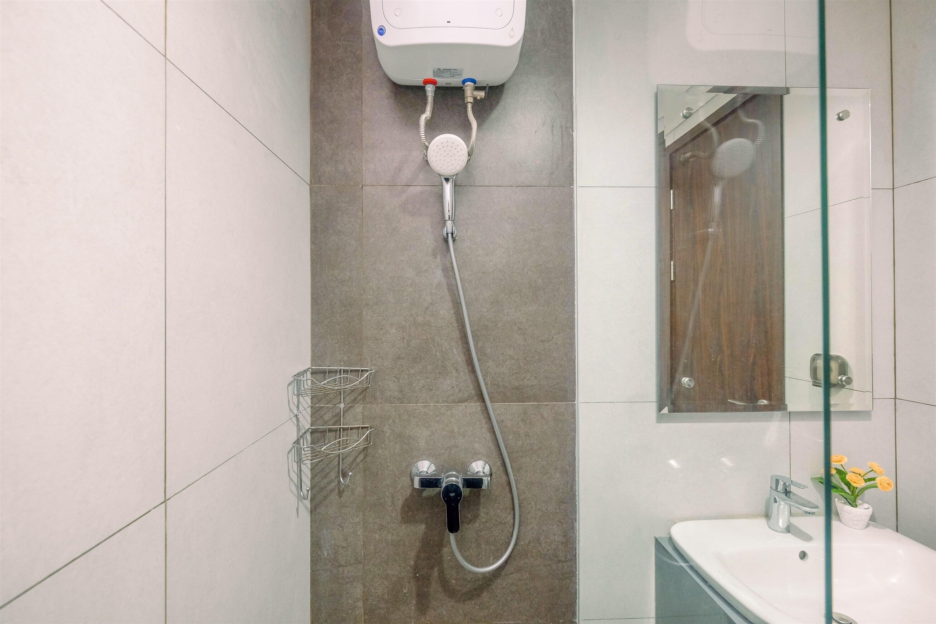 Une salle de bain avec une douche, un lavabo et un miroir.