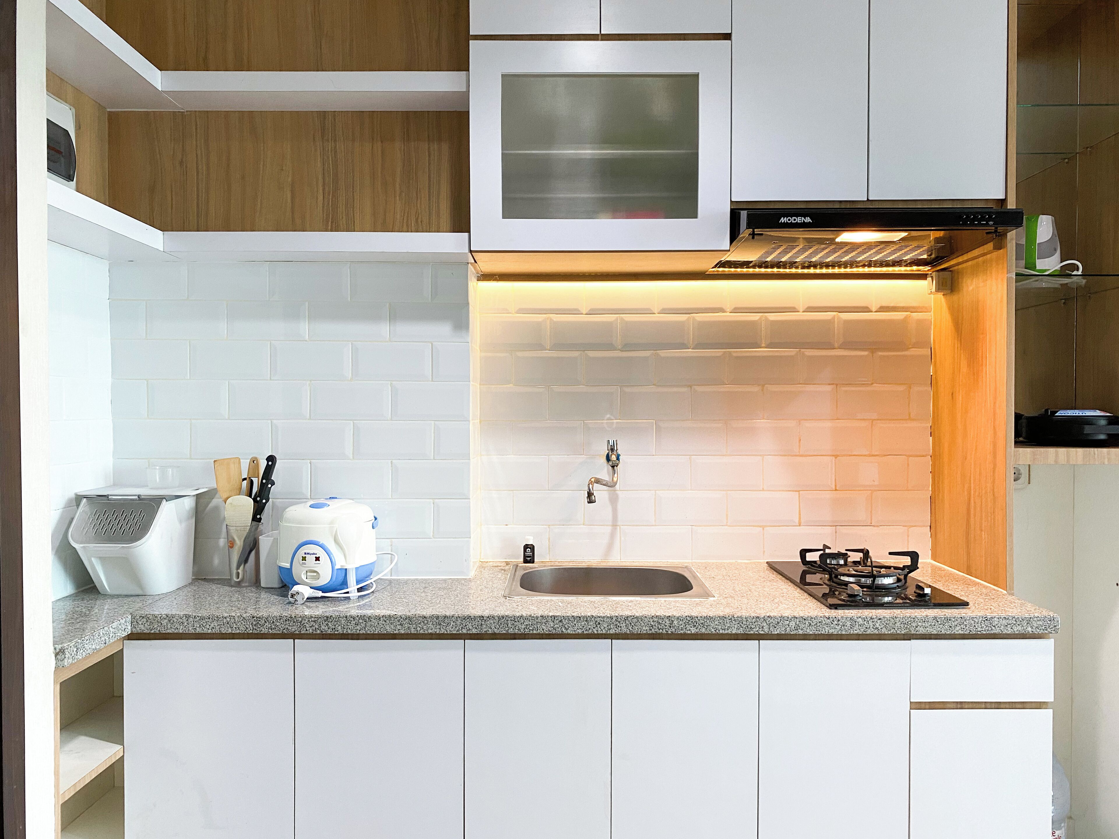 A modern kitchen with white cabinets, a granite countertop, a built-in oven, and a gas stove.